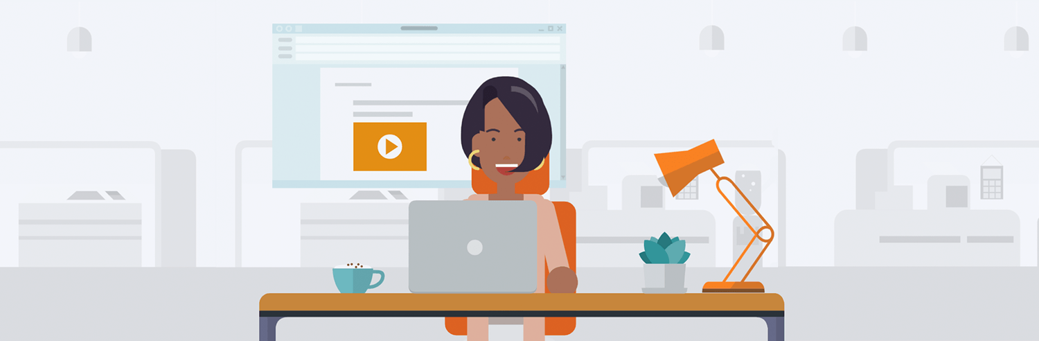 Image of a woman sitting at a computer and smiling